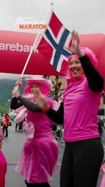 Løper med det norske flagget feirer i folkemengden