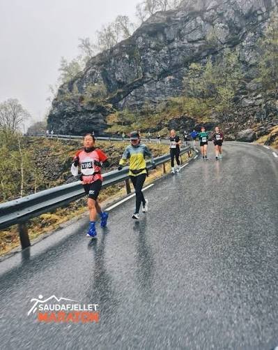 Løpere på fjellvei i regnvær under Saudafjellet Maraton